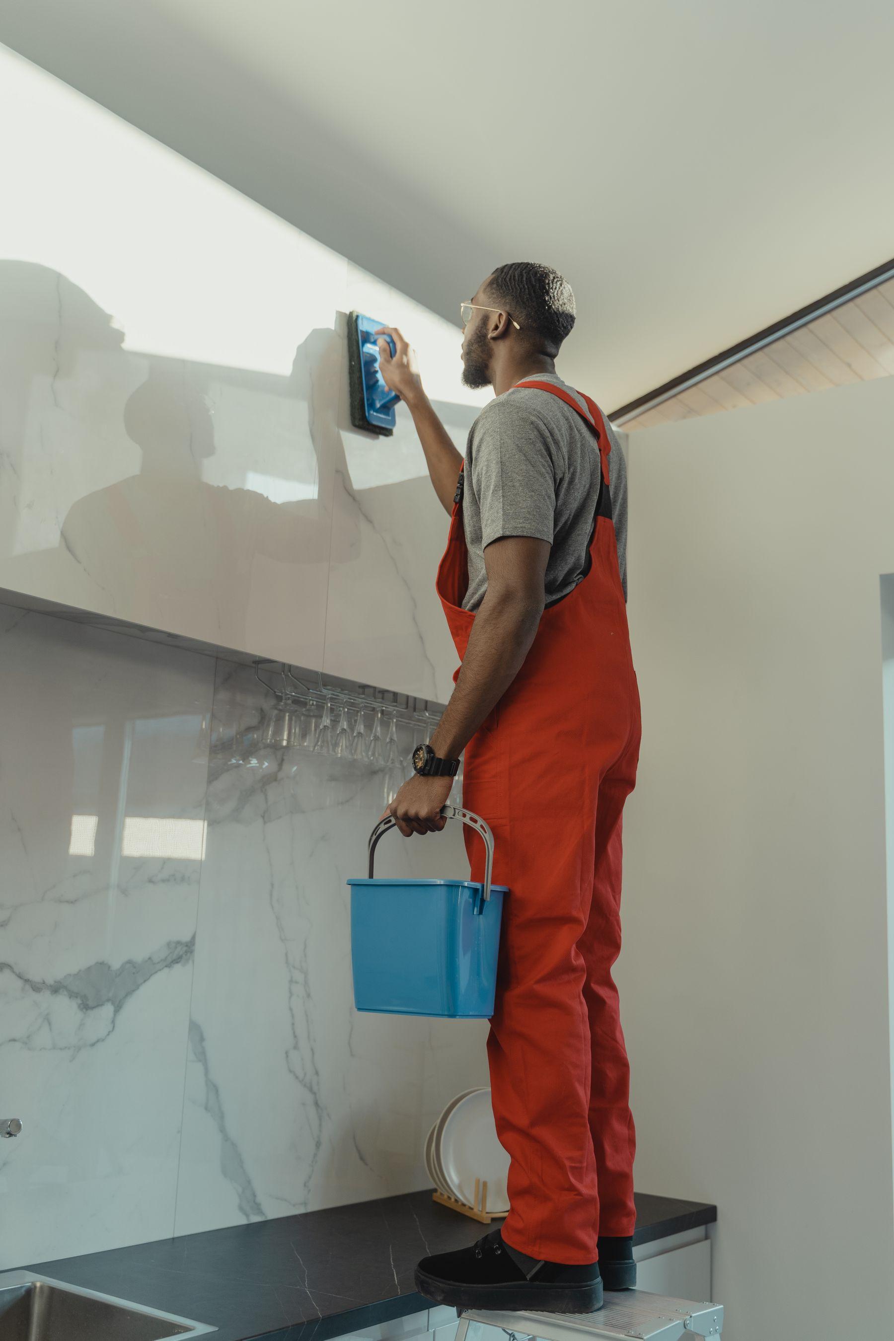 A professional cleaner carefully polishing a glass partition in a finished interior